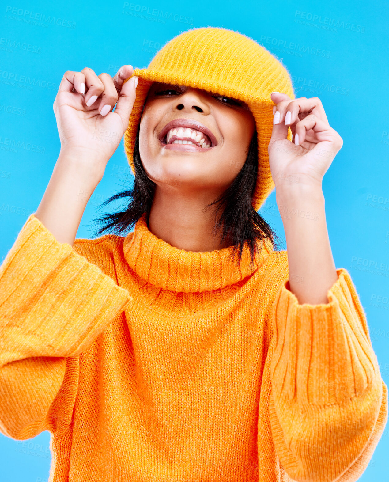 Buy stock photo Fashion, happy and cover with woman and beanie in studio for hiding, winter and goofy. Playful, happiness and smile with female and knitted hat isolated on blue background for funny, silly and cool