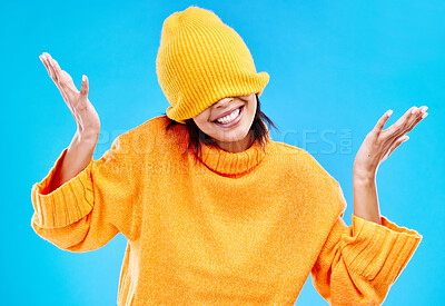 Buy stock photo Fashion, crazy and cover with woman and beanie in studio for hiding, winter and goofy. Playful, happiness and smile with female and knitted hat isolated on blue background for funny, silly and cool