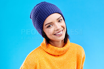 Buy stock photo Portrait of happy woman in winter fashion with smile, beanie and jersey isolated on blue background. Style, happiness and face of gen z girl in studio with hat and warm clothing for cold weather.