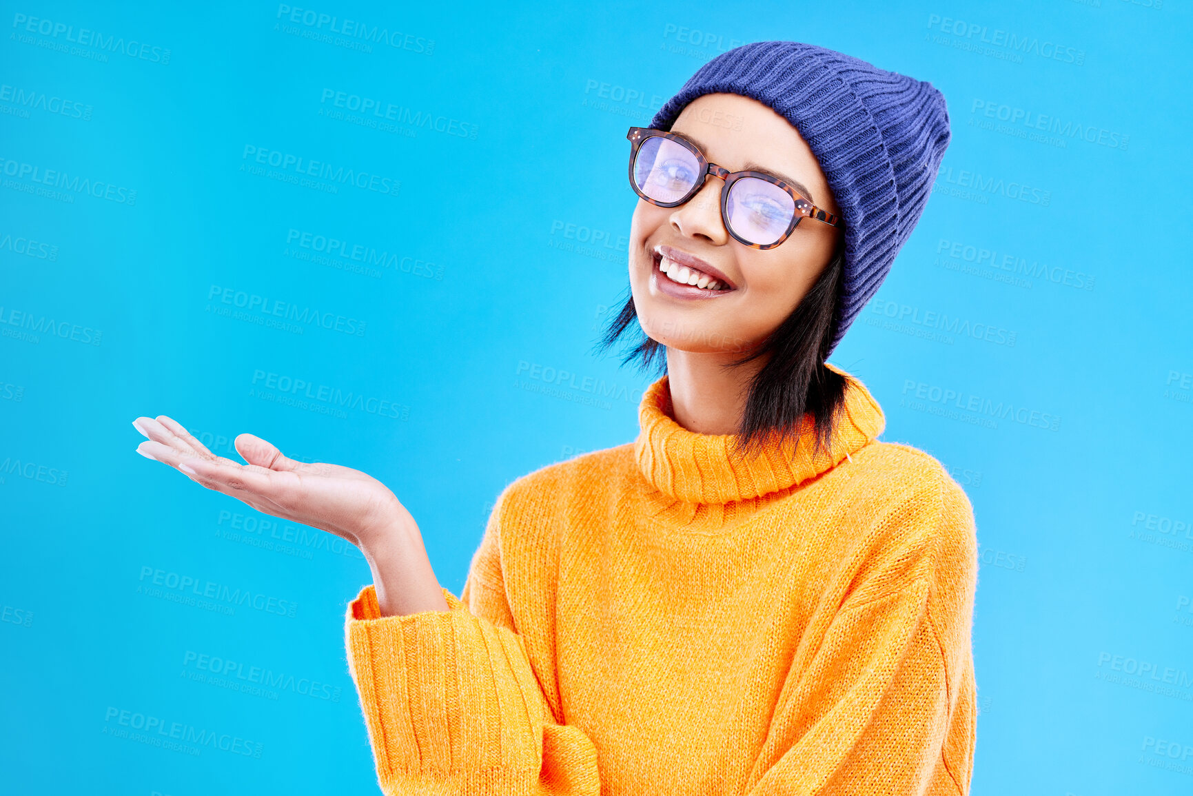 Buy stock photo Woman palm, smile and portrait in a studio with promotion and announcement. Excited, isolated and blue background with mockup of a gen z girl and cool young female show marketing with happiness