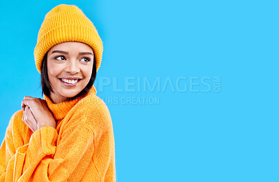 Buy stock photo Happiness, thinking and woman with fashion and mockup in studio in cold weather with winter hat. Isolated, blue background and mock up with a happy young and gen z person with a smile, beanie and joy