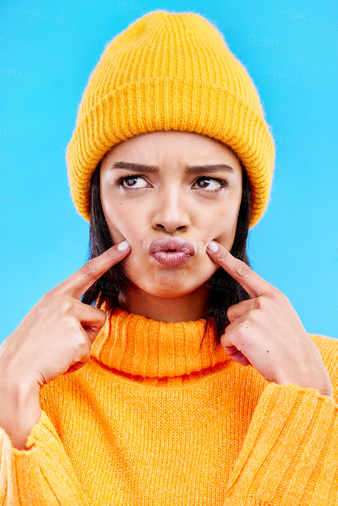 Buy stock photo Quirky, goofy and young female in a studio with a comic, funny and crazy face expression. Gen z, silly and beautiful woman model from Puerto Rico touching her cheeks isolated by a blue background.
