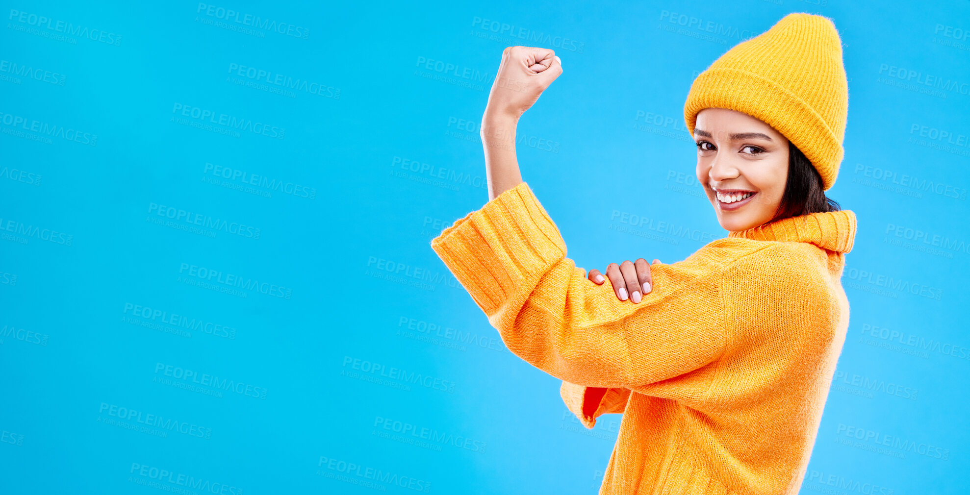 Buy stock photo Strong, mockup and a portrait of a woman with muscle isolated on a blue background in a studio. Smile, style and a girl showing fashion for empowerment and confidence on a backdrop with space