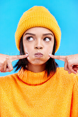 Buy stock photo Silly, goofy and young woman in a studio with a comic, funny and crazy face expression. Funny, humor and beautiful female model from Puerto Rico touching her cheeks isolated by a blue background.