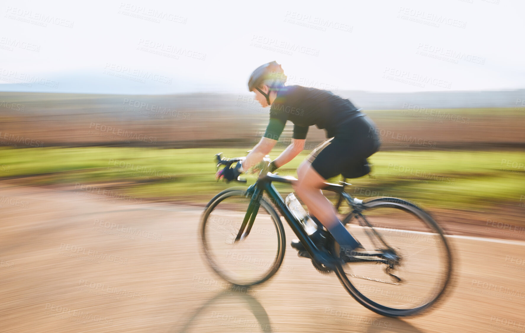 Buy stock photo Bicycle, ride outdoor and person on a bike with speed for sports race on a gravel road. Fitness, exercise and fast athlete doing sport training in nature in a park for cardio and healthy workout