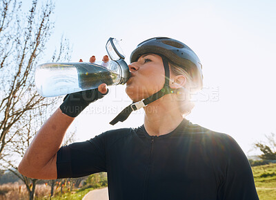 Buy stock photo Woman drinking water, bottle and cycling with fitness outdoor, helmet for safety and health with hydration. Athlete, biking and female with healthy and active lifestyle, wellness and sports training