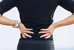 Hands, woman and back pain during fitness, training or workout routine outdoors, discomfort and sore. Spine, issue and female with sports injury, problem and arthritis, fibromyalgia or osteoporosis 