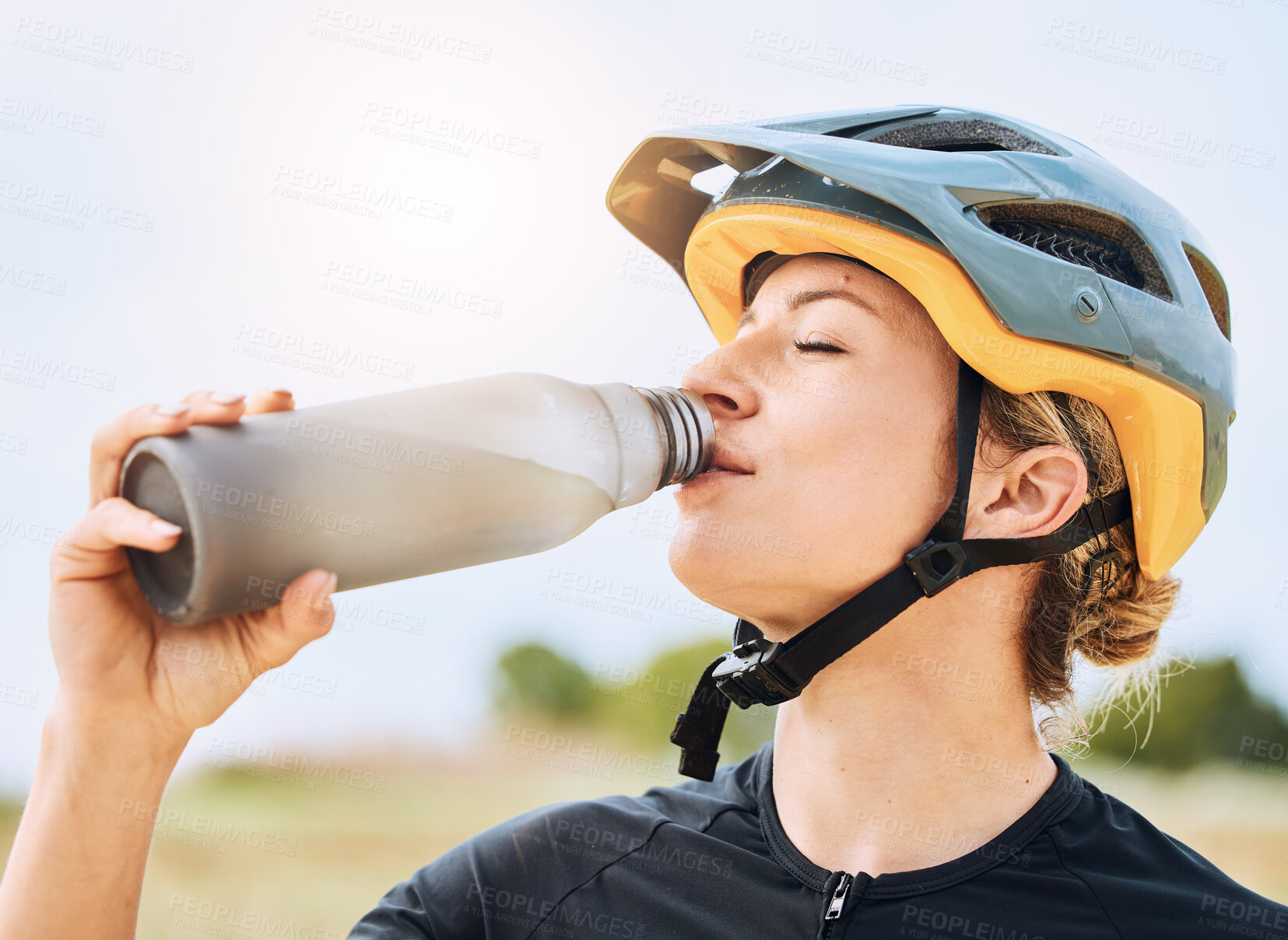 Buy stock photo Woman drinking water, bottle and cycling with exercise outdoor, helmet for safety and health with hydration. Athlete, biking and female with healthy and active lifestyle, fitness and sports training