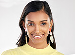 Portrait, fashion and beauty with a woman on a white background in studio wearing earrings or accessories. Face, smile and happy with an attractive young indian female closeup for contemporary style