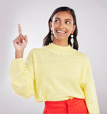Buy stock photo Woman is pointing up, smile and marketing with announcement and product placement on studio background. Advertising, logo promo and branding with happy Indian female, show with direction and choice