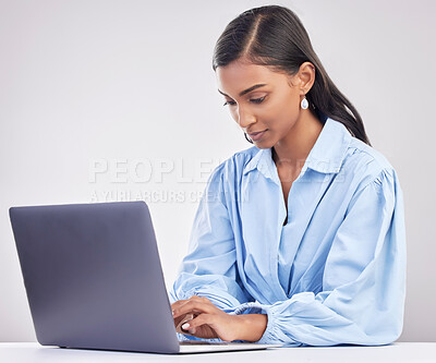 Buy stock photo Laptop, research and woman typing in a studio while working on an online corporate project. Focus, technology and professional female employee planning business report on computer by gray background.