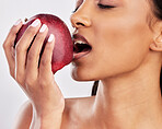 Bite, apple or healthy Indian woman with skincare beauty or wellness in studio on white background. Food nutrition, eyes closed or face of girl model eating red fruits to promote vitamin c or diet