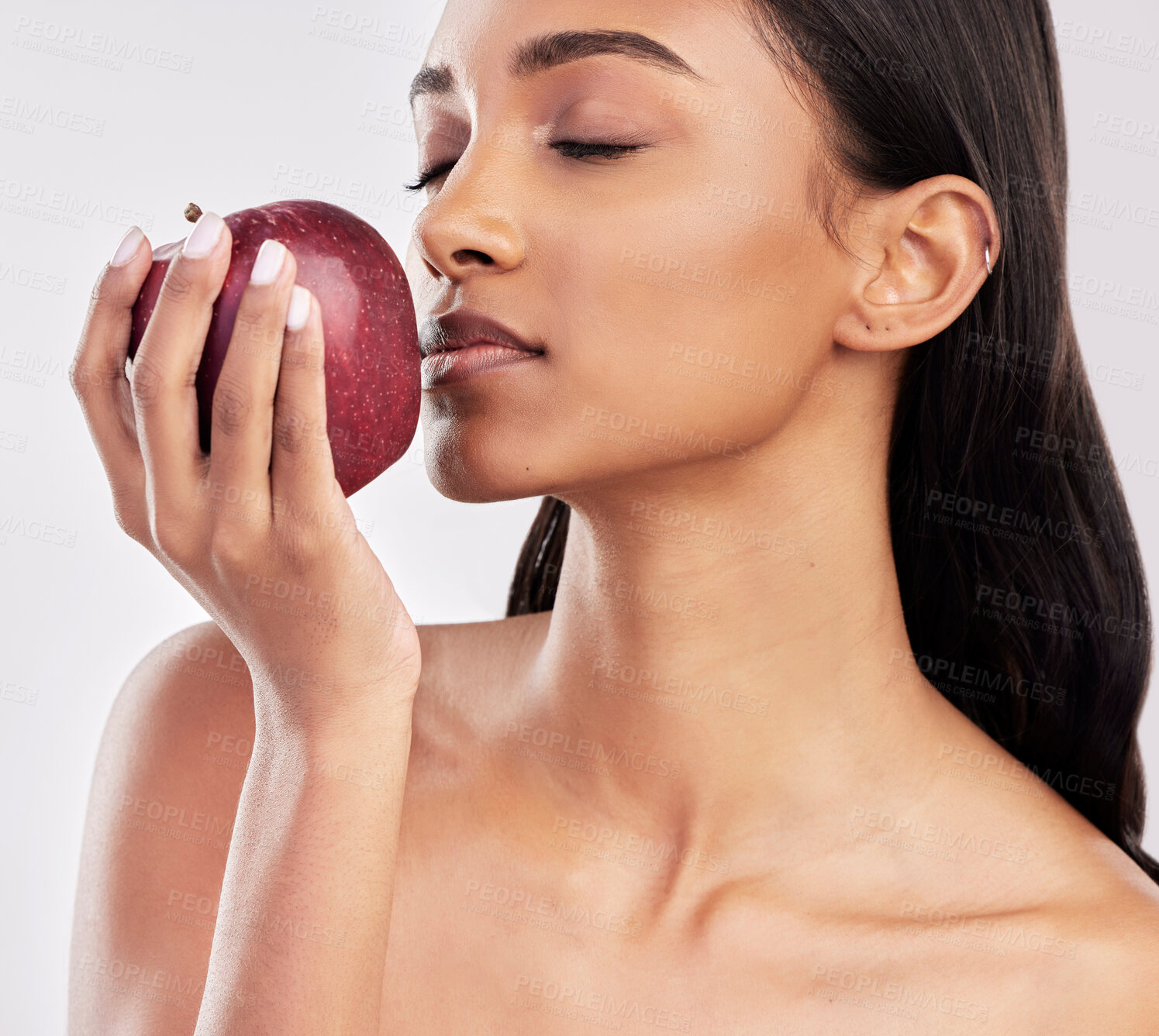 Buy stock photo Eating, apple or healthy Indian woman with skincare beauty or wellness in studio on white background. Food nutrition, eyes closed or face of girl model with red fruits to promote vitamin c or diet