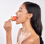 Woman, skincare and studio profile with strawberry, eating and wellness with beauty, natural glow and health. Model, diet and nutrition with fruit, cosmetics and healthy lifestyle by white background