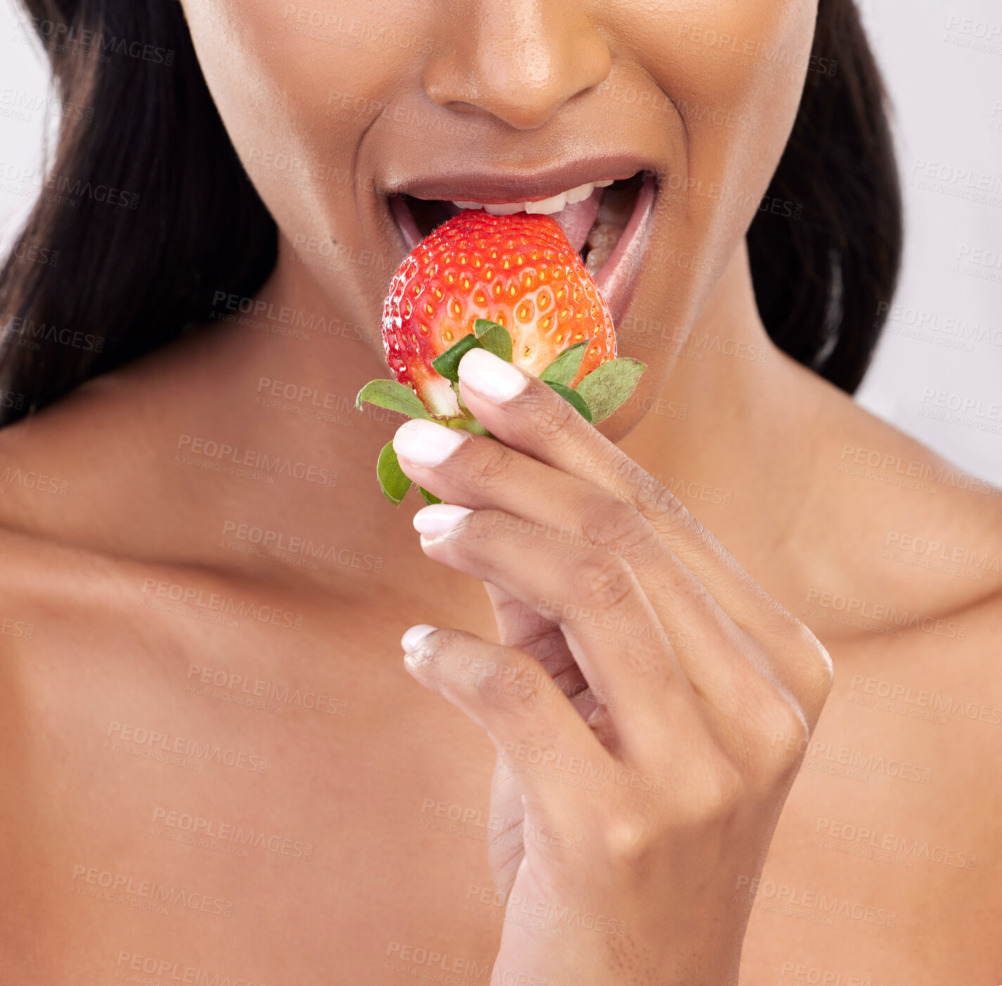 Buy stock photo Woman, diet and studio with strawberry, mouth and eating for wellness with beauty, vegan snack and health. Model, food and nutrition with biting fruit, cosmetic and seductive closeup on background