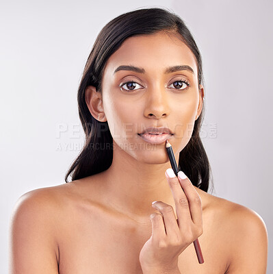 Buy stock photo Woman with lip pencil, face and portrait with makeup, beauty and cosmetic product on studio background. Indian female, cosmetics liner for lips and lipstick with healthy skin and cosmetology