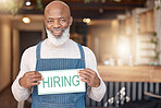 Black man, hiring sign and portrait smile in small business for recruitment, hire or job opportunity at cafe. African American senior businessman or employer with poster for recruiting or advertising