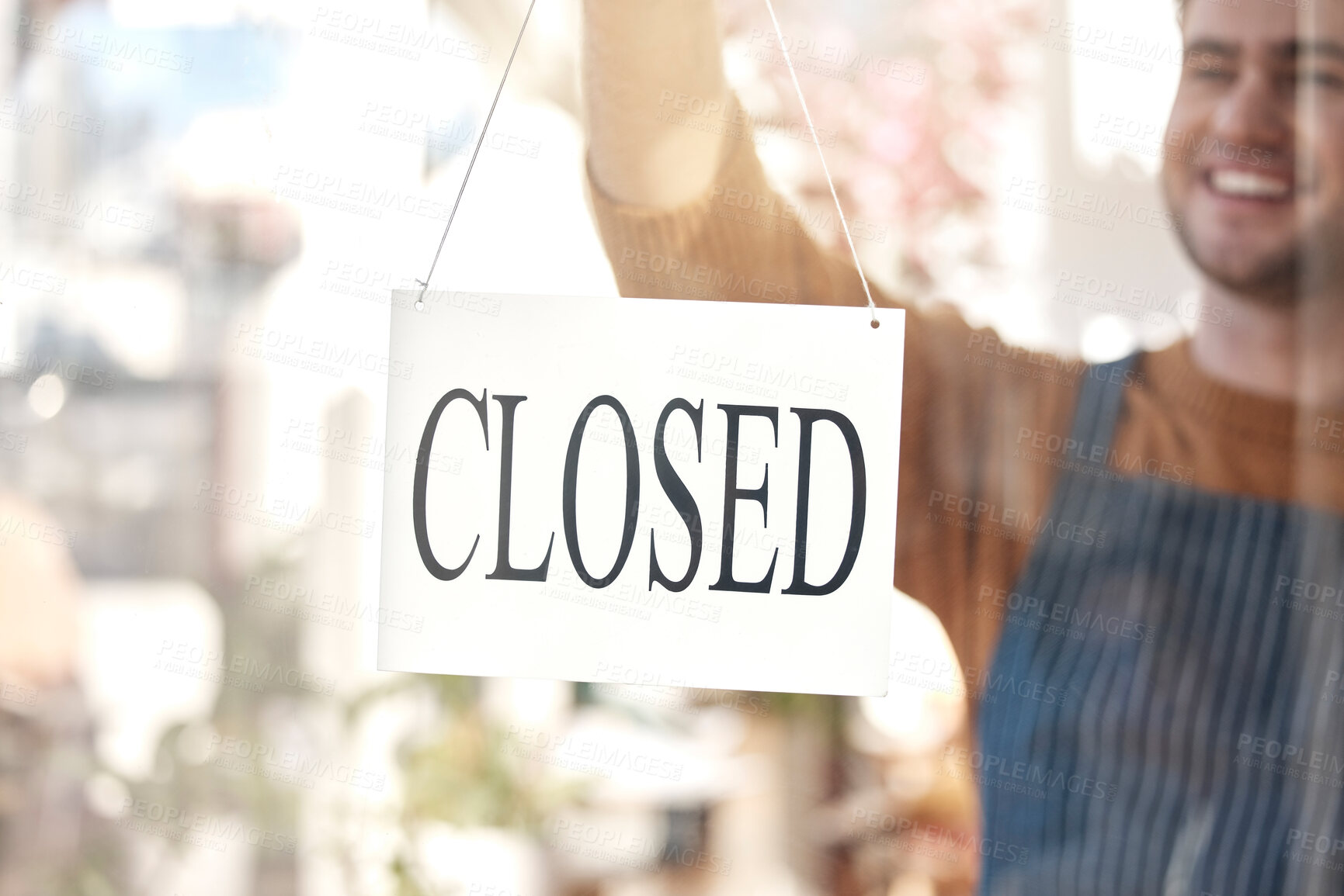 Buy stock photo Closed, sign and happy man at shop, store and notice of retail closing time, board and advertisement. Closeup of employee advertising end of business to public, signage or information on glass window