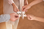 Business people, hands and puzzle piece in planning, teamwork or brainstorming for collaboration at office. Hand of group in team building, strategy or activity for engagement, support or interaction