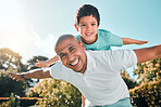 Portrait, piggyback and a son flying on the back of his father outdoor in the garden while bonding together. Family, children or love and a boy playing with his dad in the backyard of their home