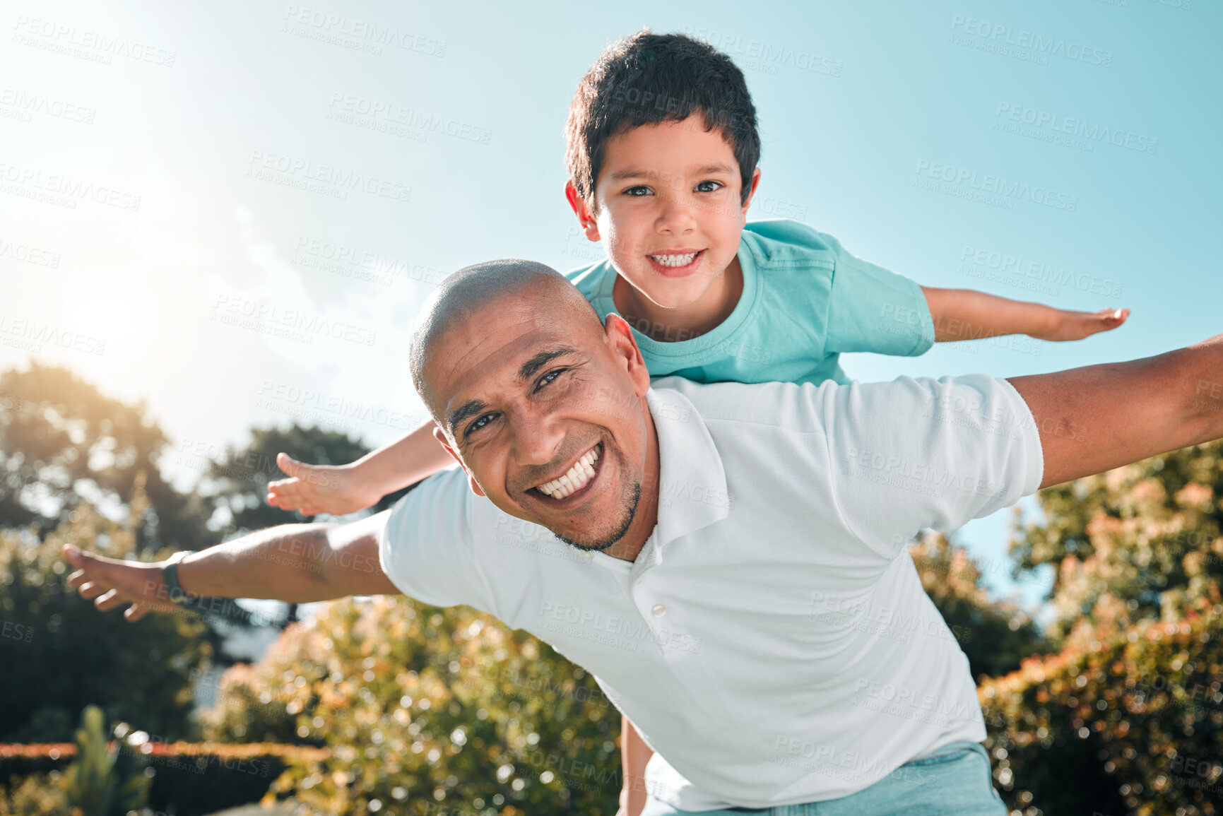 Buy stock photo Portrait, piggyback and a son flying on the back of his father outdoor in the garden while bonding together. Family, children or love and a boy playing with his dad in the backyard of their home