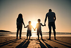 Family silhouette at the beach, holding hands at sunrise and people with love, care and support outdoor. Mom, dad and kids travel, back and ocean view with parents and children outdoor in nature