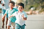 Running, playful and portrait of children at the beach for a holiday, weekend fun and bonding. Happy, freedom and boy kids at the sea in nature to run, play and be free with family on vacation