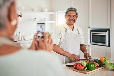 Buy stock photo Kitchen cooking, senior couple and phone picture of old man, husband or nutritionist person with memory photo. Vegan, vegetables or people recording web video, smile or cutting lunch food ingredients