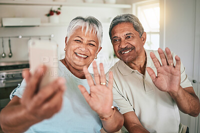 Buy stock photo Video call, waving and elderly couple on phone, happy and smile in their home kitchen. Smartphone, love and old people greeting, excited and cheerful for online conversation and enjoying retirement