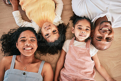 Buy stock photo Portrait, above and happy family on a floor, smile and bonding in a living room together. Top view, love and face of children with parents, relax and cheerful while having fun, lying and chilling