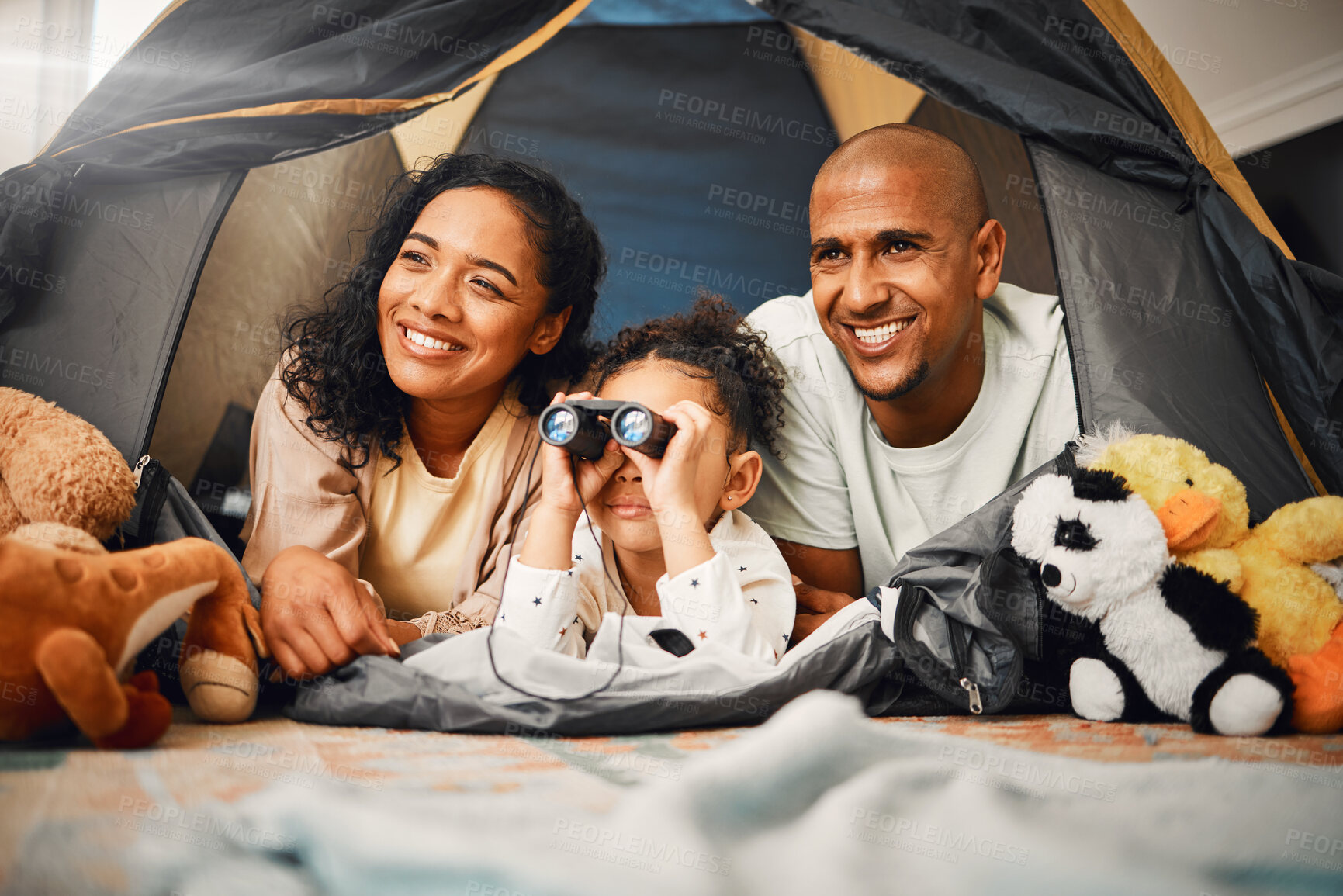 Buy stock photo Parents, girl and binoculars in tent, home and smile for games, toys or bonding with love for playing together. Mom, kid and dad with camping game, looking or search in house with happiness on floor