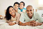 Family, bed and portrait of parents and kids bonding in a bedroom in a house and playing together. Care, mother and father happy and excited with children in the morning as love and care