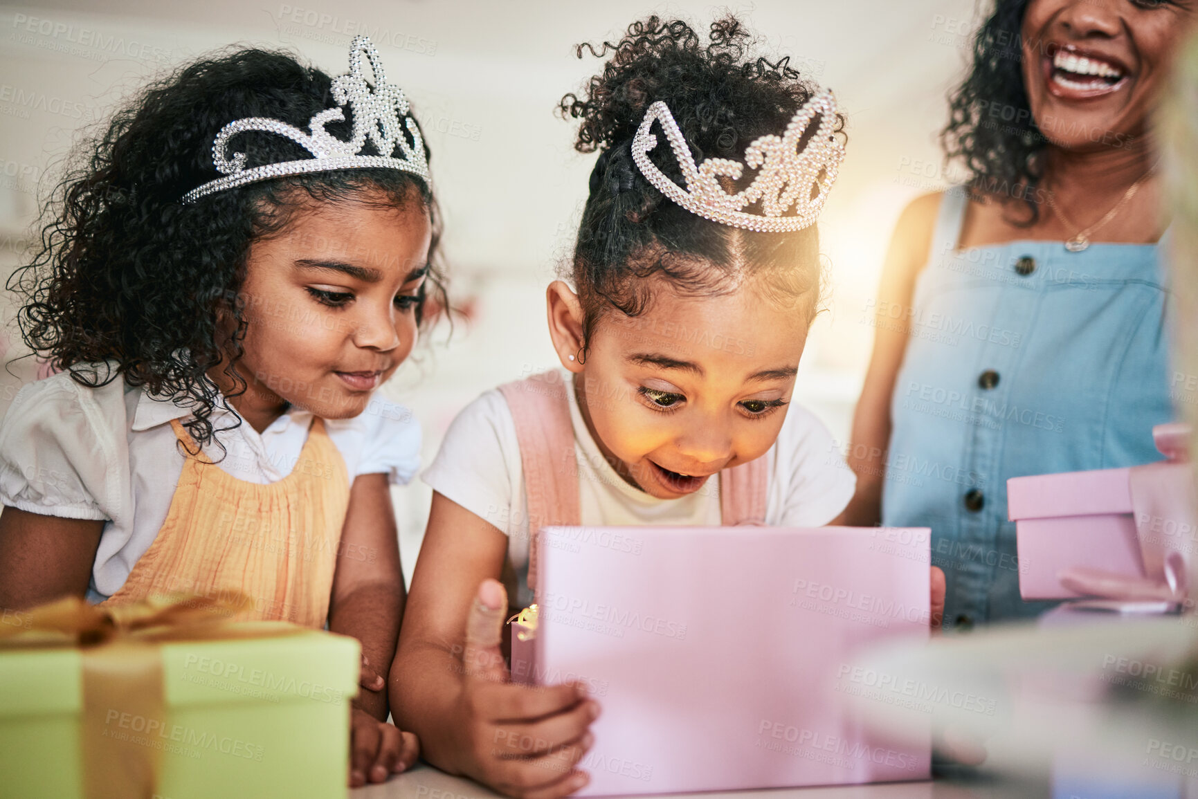 Buy stock photo Girl child, box and wow for gift, surprise or happiness for princess at birthday in family home. Female kid, present and smile with mother, sister and happy at party with tiara, love or bond in house