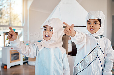 Buy stock photo Astronaut, home and children pointing, playing and role play space travel, fantasy games or explore new discovery. Rocket spaceship, creative halloween costume and kids imagine a galaxy adventure