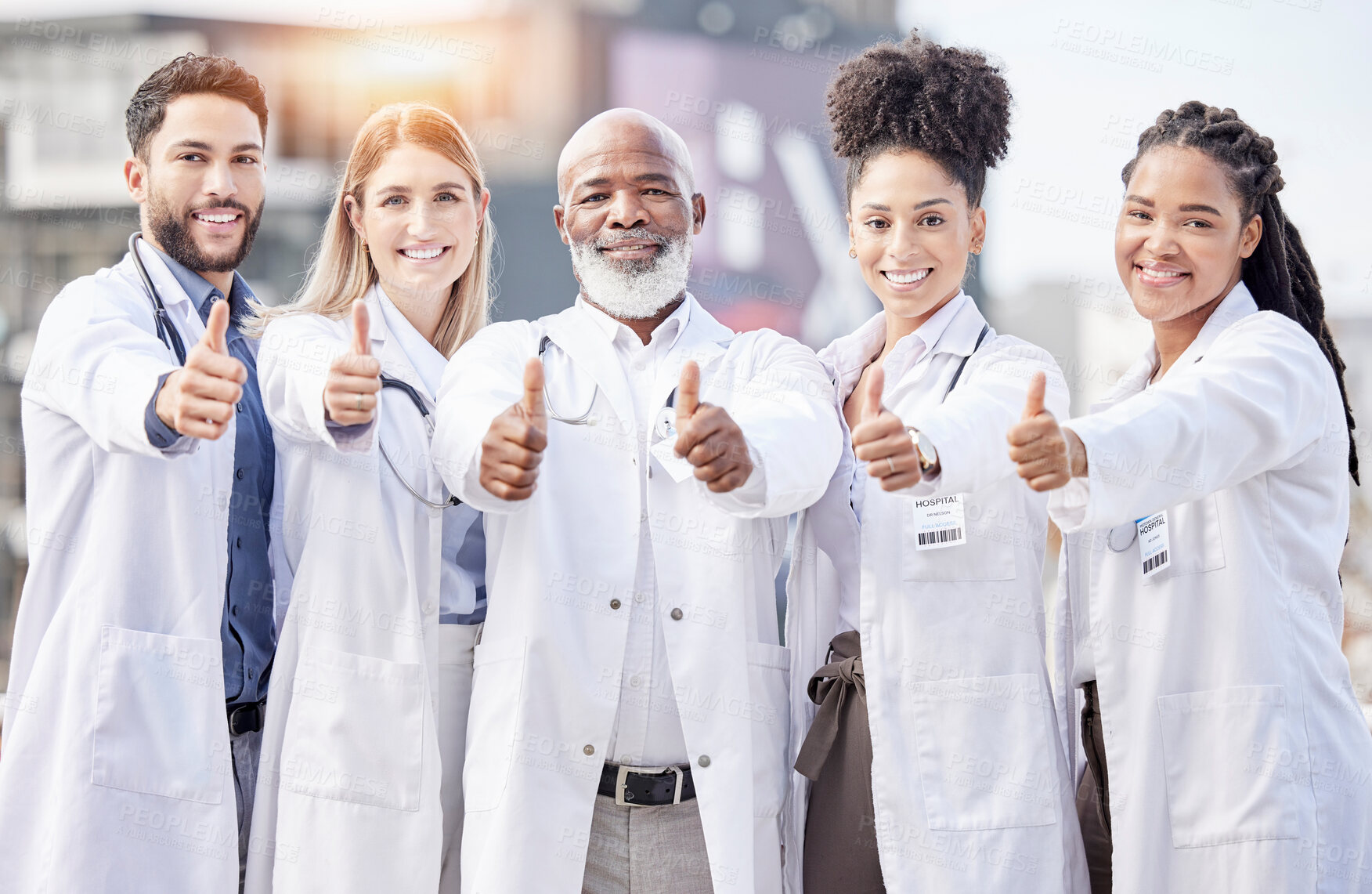 Buy stock photo Portrait, collaboration and thumbs up with a team of doctors standing outside of a hospital together. Teamwork, thank you or motivation with a team of professional healthcare workers feeling positive