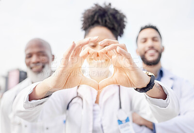 Buy stock photo Heart hand, happy and portrait of doctors in the city for healthcare, medical attention and care. Smile, medicine and hospital workers showing love with emoji hands for professional nursing as a team