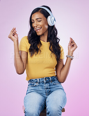 Buy stock photo Music, headphones and Indian woman dance on pink background listening to track, audio and radio. Relax, happy and isolated girl singing streaming song for dancing, chilling and happiness in studio