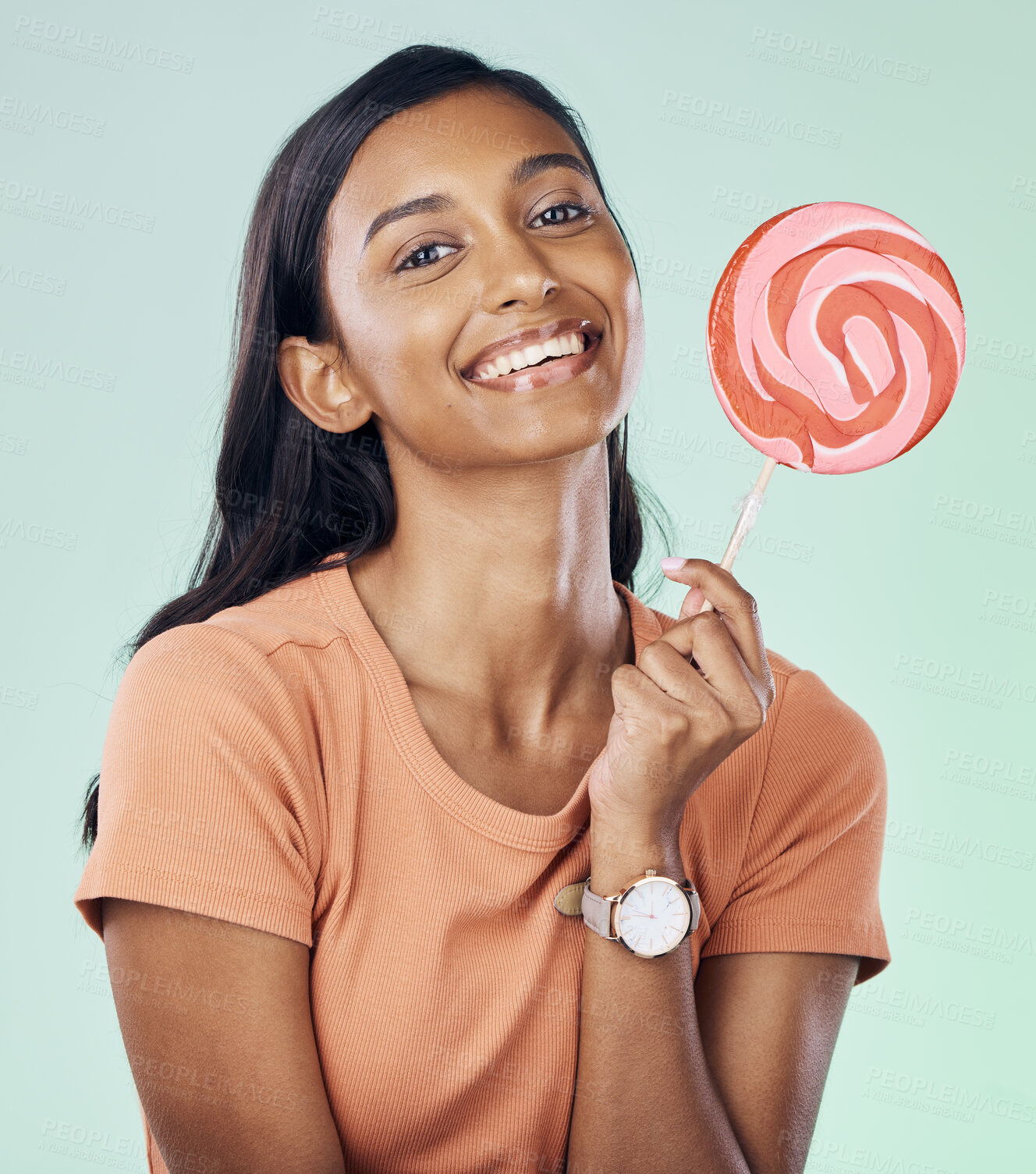 Buy stock photo Happy, lollipop portrait and studio woman with candy, junk food or dessert product for delicious snack. Happiness, smile or Indian gen z person with sweets, sucker or sugar treats on green background
