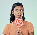 Thinking, lollipop and woman with candy in studio isolated on a green background. Idea, sweets and Indian person with snack, delicious sucker or sugar treats, dessert or confectionery junk food.