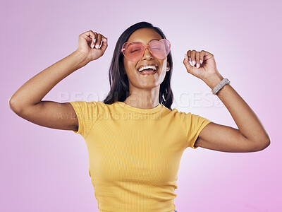 Buy stock photo Dance, sunglasses and happy woman excited, cool and confident isolated in a pink studio background with joy. Singing, music and young gen z female dancing celebration of a party energy with glasses