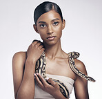 Beauty, portrait and woman in studio with snake on neck for art aesthetic with exotic zoo animal on white background. Face, danger and creative style, asian fashion model holding dangerous pet python