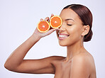 Skincare, orange and woman in studio for vitamin c, treatment and cosmetics on purple background. Smile, fruit and girl model relax with diy facial, organic and skin, beauty and citrus cleaning