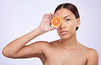 Orange, skincare and woman portrait in studio for vitamin c, treatment and cosmetics on purple background. Face, fruit and girl model relax with diy facial, organic or skin detox with citrus cleaning