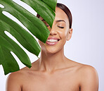 Smile, leaf and woman in studio for skincare, dermatology and cosmetic on purple background. Beauty, face and girl model relax, calm and happy with glowing skin, cosmetology or monstera treatment