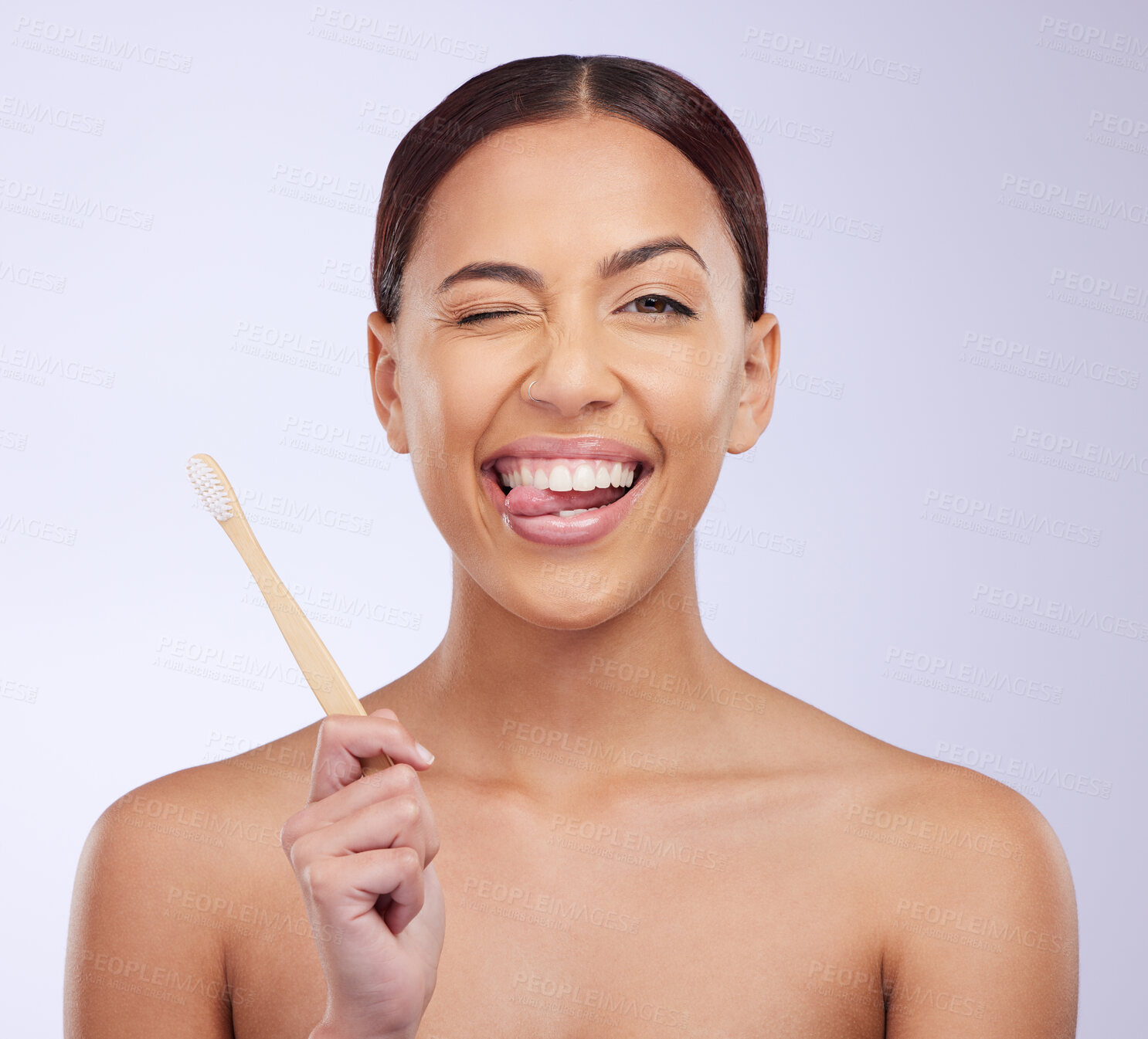Buy stock photo Portrait, wink or happy girl brushing teeth with smile for healthy oral or dental hygiene in studio. Face, beauty or Brazilian woman model cleaning mouth with a natural bamboo wooden toothbrush 