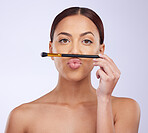 Makeup, pout or portrait of woman with brush in studio with facial cosmetics or skincare products. Beauty, face grooming application or young girl model isolated on white background with mockup space