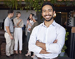 Portrait, smile and a professional business man in the office, standing arms crossed with his team in the background. Corporate, happy and confident with a young male employee at a work function