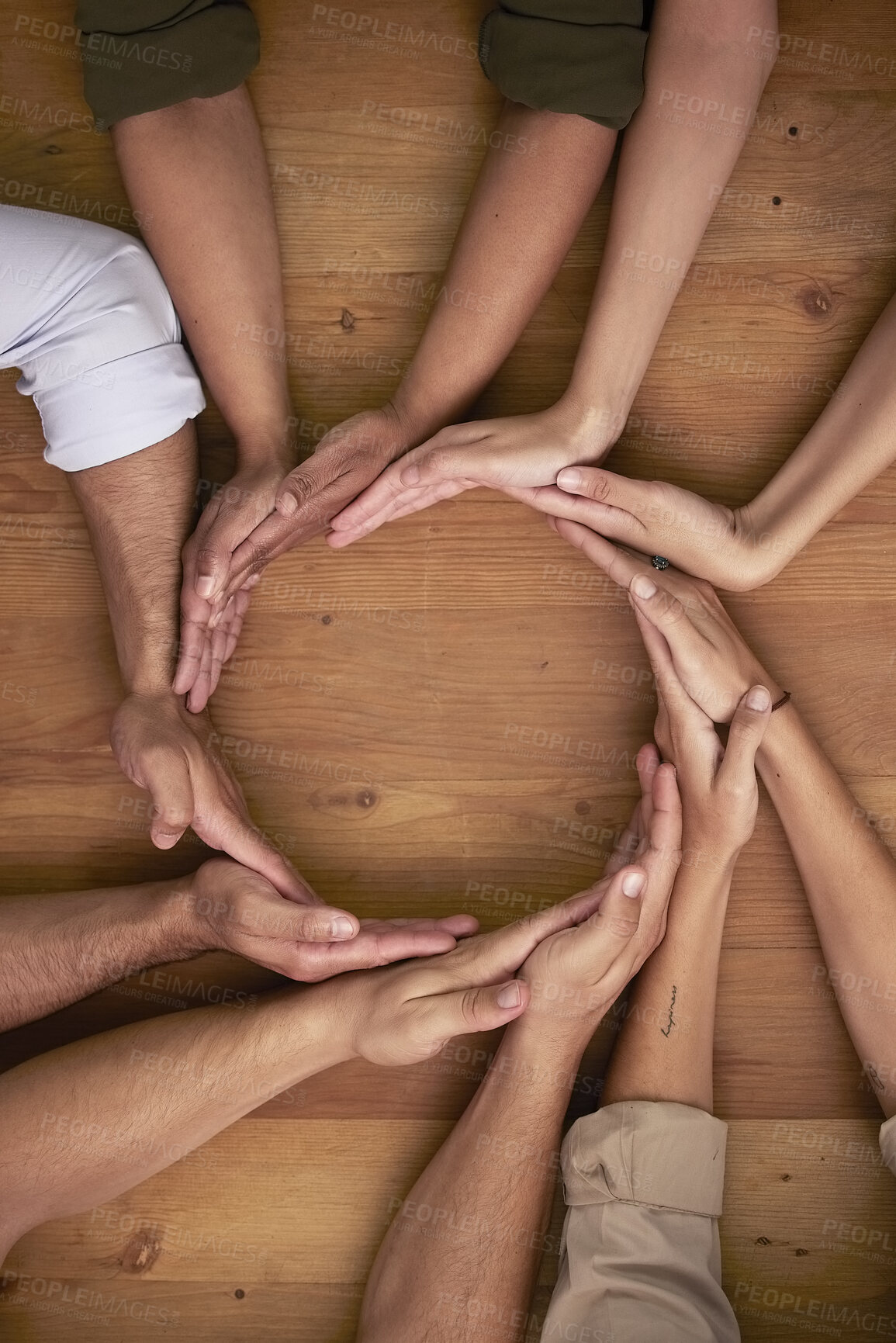 Buy stock photo Hands, teamwork and circle with business people on a wooden table in the office closeup from above. Collaboration, synergy and an employee group or team together in a huddle during a meeting at work
