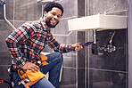 Portrait, man and plumber with smile, maintenance and installation with home repairs. Face, Nigerian male employee or worker with tools, fixing pipes and sink with handyman, contractor and renovation