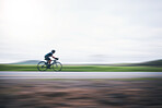 Person cycling fast with motion blur, sky mockup and bike in countryside, triathlon and cardio training. Athlete, bicycle and marathon race with speed, energy and sports for exercise, power or action